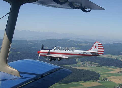 In Formation kommt eine Jak 52.