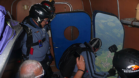 Fallschirmspringer geben letzte Korrekturen dem Piloten.