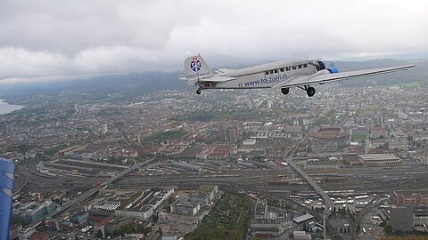 Über der Stadt Zürich hat die An-2 die eingeholt, nein sie fliegt etwas langsamer zum fotografieren!